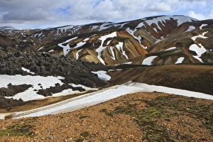 Cooled lava field with snow fields in a volcanic landscape, Landmannalaugar, Iceland Cooled lava field with snow fields in a volcanic landscape, Landmannalaugar, Iceland