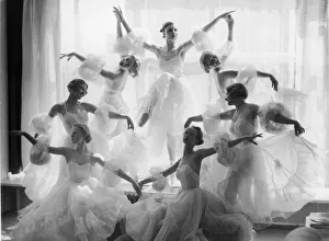 <b class=qtipBold><figcaption>Corps De Ballet</figcaption></b><br>A group of ballerinas in matching sheer dresses with separate puff sleeves pose in various stances in a symmetrical formation in front of a window with light streaming in, 1930s. The dancer at the top of the arrangement stands on pointe, her leg bent in attitude. (Photo by FPG/Getty Images)<br><em>© 2005 Getty Images</em> Corps De Ballet