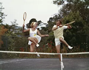Togetherness Gallery: Couple jumping on tennis court, smiling