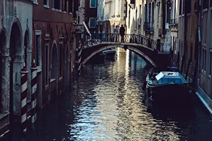 Couple standing on the bridge above canal in Venice, Italy Couple standing on the bridge above canal in Venice, Italy