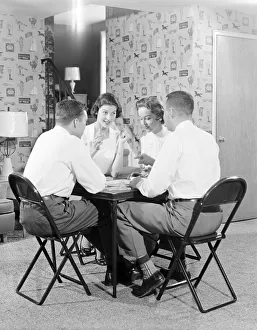 Two couples playing bridge around card table. (Photo by H Two couples playing bridge around card table. (Photo by H