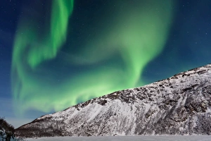 <b class=qtipBold><figcaption>Dancing Aurora</figcaption></b><br>Northern Lights (Aurora Borealis) over GrotfjAžrd, KvalAžya (lit. Whale Island). KvalAžya is a montainous island located in Troms county in northern Norway. Moonlit, snowcapped mountains.<br><em>© Krzysztof Baranowski</em> Dancing Aurora