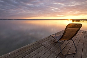 Deckchair on a jetty, early morning at Lake Starnberg near Seeshaupt, Bavaria, Germany Deckchair on a jetty, early morning at Lake Starnberg near Seeshaupt, Bavaria, Germany