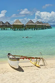 Decorated outrigger boat in front of overwater bungalows, Bora Bora, French Polynesia Decorated outrigger boat in front of overwater bungalows, Bora Bora, French Polynesia