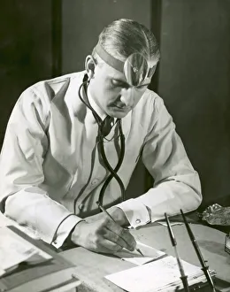 Doctor writes at his desk