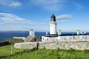 Dunnet Head lighthouse on the north coast of Scotland, Orkney Islands at back on the Dunnet Head lighthouse on the north coast of Scotland, Orkney Islands at back on the