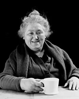 Elderly woman smiling, holding coffee cup, portrait