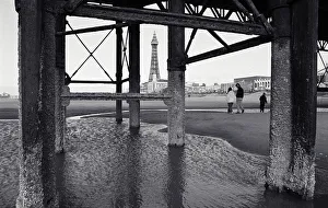 Father with children (10-13) on beach, view through pier supports Father with children (10-13) on beach, view through pier supports