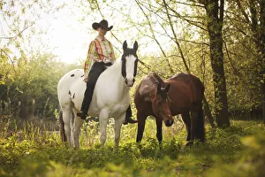 Female western rider on a Paint Horse, Black Tobiano colour pattern Female western rider on a Paint Horse, Black Tobiano colour pattern
