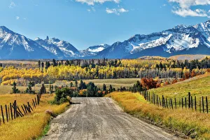 Fence and dirt road leading to San Juan Mountain Range, Ridgway, Colorado, USA Fence and dirt road leading to San Juan Mountain Range, Ridgway, Colorado, USA