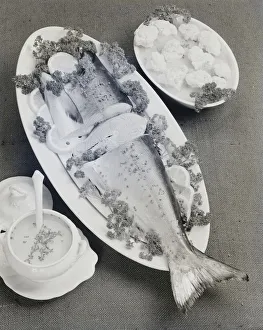 Fish garnished with lemon and coriander in plate, close-up Fish garnished with lemon and coriander in plate, close-up