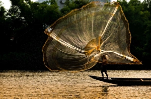 Fisherman catch fish in the river in Hue, Vietnam Fisherman catch fish in the river in Hue, Vietnam
