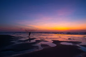 Fisherman walking on the beach at dawn in Vietnam Fisherman walking on the beach at dawn in Vietnam