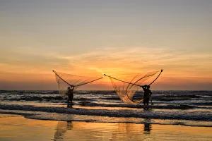 Two Fishermen fishing on the beach at dawn in Vietnam Two Fishermen fishing on the beach at dawn in Vietnam