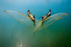 Fishermen throw fishing net on boats to catch fish in Hue, Vietnam Fishermen throw fishing net on boats to catch fish in Hue, Vietnam
