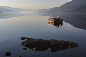 Fishing boat on Loch Arkaig in the early morning, Fort William, Highlands, Scotland Fishing boat on Loch Arkaig in the early morning, Fort William, Highlands, Scotland