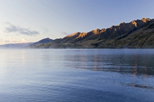 Fog over Lake Hawea, mountain slopes in the morning light, Hunter Valley, Otago Region Fog over Lake Hawea, mountain slopes in the morning light, Hunter Valley, Otago Region