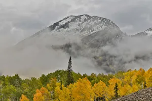 Fog rising around East Beckwith Mountain near Crested Butte in fall colors, Colorado, USA Fog rising around East Beckwith Mountain near Crested Butte in fall colors, Colorado, USA