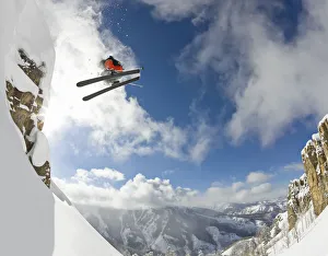 Freestyle skier spinning while jumping off of cliff Freestyle skier spinning while jumping off of cliff