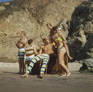 Friends in swimwear playing guitar and piano on beach Friends in swimwear playing guitar and piano on beach