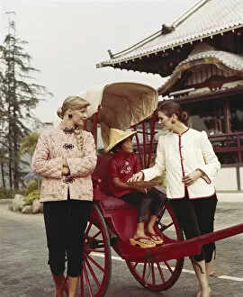 Girl sitting in horsedrawn cart, women standing besides