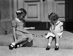 Girls sitting on steps outdoors, playing jacks Girls sitting on steps outdoors, playing jacks