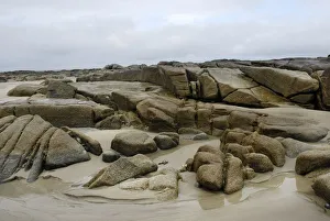 Granite rocks in tidal zone of sandy beach at the Altanic coast of Donegal on a foggy day Granite rocks in tidal zone of sandy beach at the Altanic coast of Donegal on a foggy day