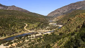 A gravel road in a mountainous area crossing over a river on a low level bridge near A gravel road in a mountainous area crossing over a river on a low level bridge near