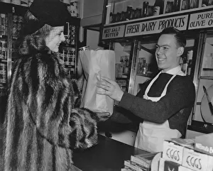 <b class=qtipBold><figcaption>At The Grocery Store</figcaption></b><br>A woman collects her paper bag of shopping from an assistant behind the counter at the grocery store circa 1930's. (Photo by Keystone View/FPG/Getty Images)<br><em>© 2011 Getty Images</em> At The Grocery Store