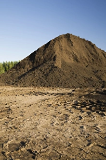 Heavy tire tracks and a mound of topsoil in a commercial sandpit, Quebec, Canada Heavy tire tracks and a mound of topsoil in a commercial sandpit, Quebec, Canada