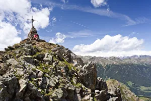 Hiker on the summit of Spitzen Kornigls Mountain, overlooking the Val dUltimo, Ultimo Hiker on the summit of Spitzen Kornigls Mountain, overlooking the Val dUltimo, Ultimo