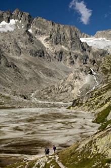 Hikers on the Baechlisboden floodplain, with Baechlital Hut on a ledge, Baechli Valley, Bernese Alps, Switzerland Hikers on the Baechlisboden floodplain, with Baechlital Hut on a ledge, Baechli Valley, Bernese Alps, Switzerland