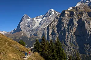 Hikers at the foot of Eiger and Moench Mountains and Eiger glacier, Murren Hikers at the foot of Eiger and Moench Mountains and Eiger glacier, Murren