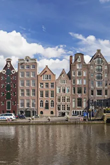 Historic buildings along the Damrak canal in Amsterdam, Holland, Netherlands, Europe Historic buildings along the Damrak canal in Amsterdam, Holland, Netherlands, Europe