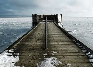 Hole in the ice for winter bathing by a jetty Hole in the ice for winter bathing by a jetty
