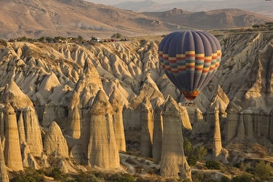 Hot air balloon flying over rock landscape at Cappadocia Turkey Hot air balloon flying over rock landscape at Cappadocia Turkey