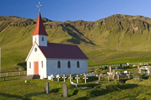 Iceland, church and graveyard in mountainous landscape Iceland, church and graveyard in mountainous landscape