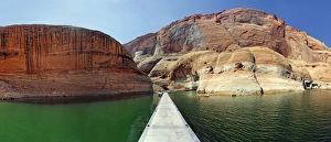 Jetty and red Navajo sandstone cliffs, rock formations rising from Lake Powell, Page Jetty and red Navajo sandstone cliffs, rock formations rising from Lake Powell, Page