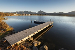 Jetty and rowing boat on the shore of Hopfensee Lake near Fuessen, Ostallgaeu region Jetty and rowing boat on the shore of Hopfensee Lake near Fuessen, Ostallgaeu region