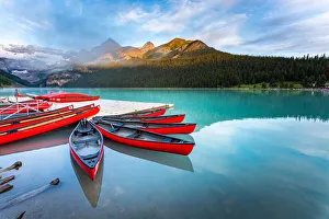 Lake Louise, canoe and kayak on calm water at sunrise. Banff, Canadian Rockies, Canada Lake Louise, canoe and kayak on calm water at sunrise. Banff, Canadian Rockies, Canada