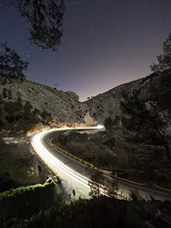 Lights of vehicles circulating along a road with curves during the night Lights of vehicles circulating along a road with curves during the night