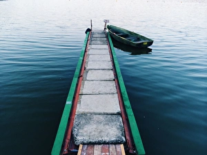 Lone boat at the pier near lake in Moldova Lone boat at the pier near lake in Moldova