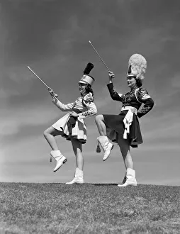 Two majorettes in uniform doing routine with batons Two majorettes in uniform doing routine with batons