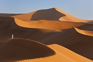 Man Climbing Sand Dunes, Namib Desert, Namibia Man Climbing Sand Dunes, Namib Desert, Namibia