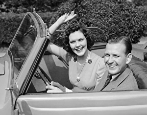 <b class=qtipBold><figcaption>Man driving car and woman waving</figcaption></b><br>UNITED STATES - CIRCA 1950s: Man driving car and woman waving.<br><em>© George Marks</em> Man driving car and woman waving