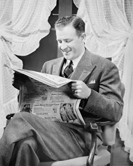 Man reading newspaper in living room, (B&W) Man reading newspaper in living room, (B&W)