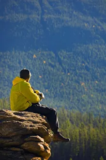 Man sitting on a mountain in Jasper National Park, Alberta Man sitting on a mountain in Jasper National Park, Alberta
