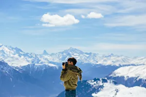 A Man taking a photo with the background of Alps A Man taking a photo with the background of Alps