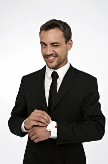 Man wearing a suit pulling an ace of hearts out of his sleeve Man wearing a suit pulling an ace of hearts out of his sleeve