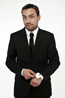 Man wearing a suit pulling an ace of spades out of his sleeve Man wearing a suit pulling an ace of spades out of his sleeve